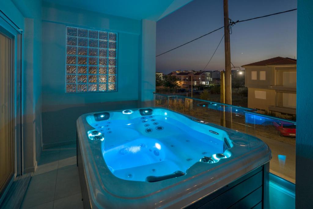 a blue bath tub in a room with a window at Emerald Luxury Apartments in Nikiti