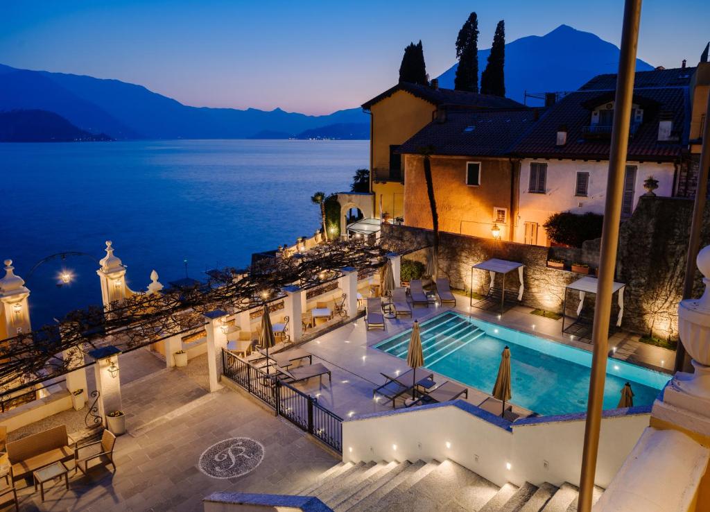a villa with a swimming pool at night at Hotel Royal Victoria, by R Collection Hotels in Varenna