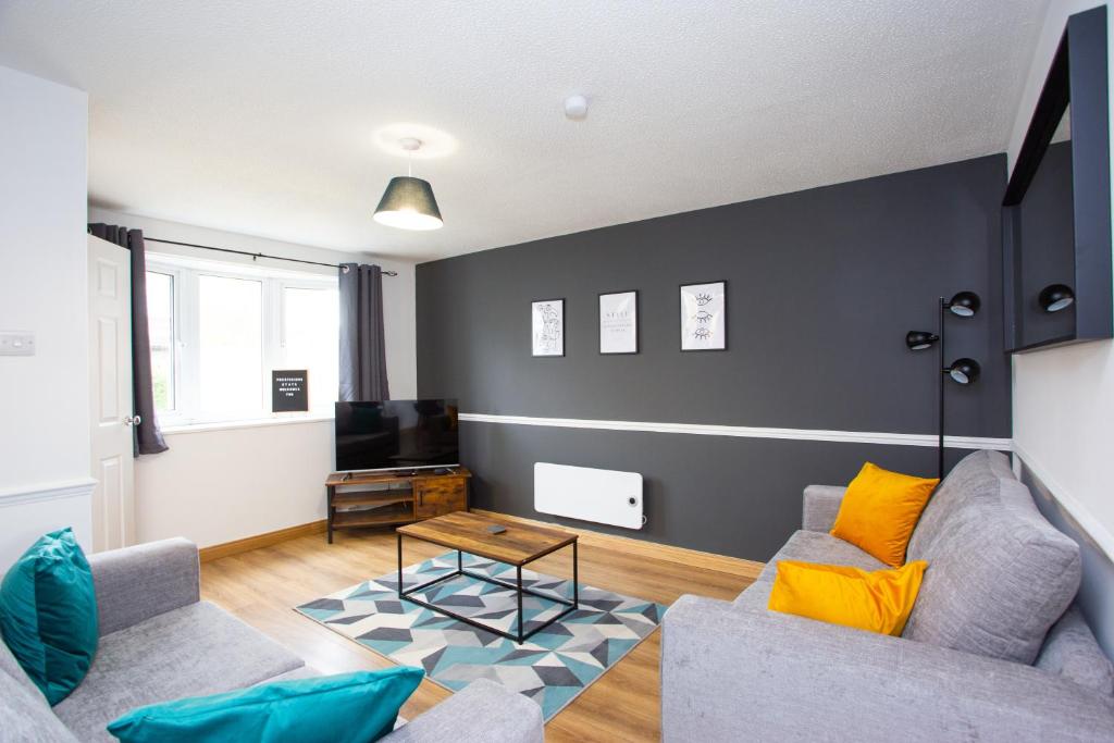 a living room with a couch and a tv at GERARD WALK - Spacious Home, High Speed Wi-Fi, Free Parking, Garden in Swindon