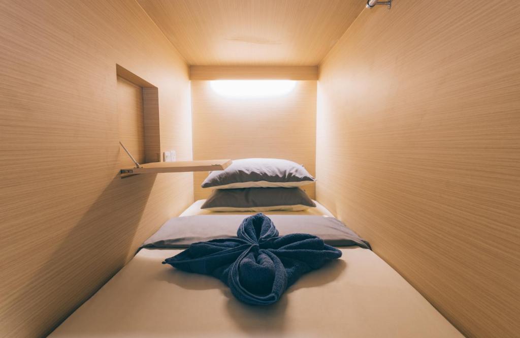 シンガポールにあるWanderloft Capsule Hostelの青い弓を用いたベッド2台が備わる客室です。