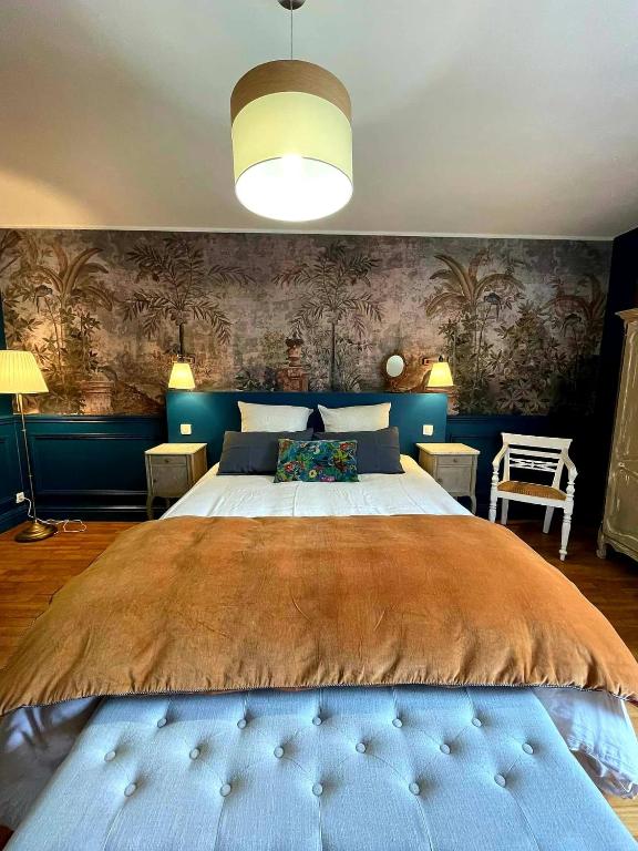 a bedroom with a large bed with blue walls at NAMASTE COTTAGE in Issigeac