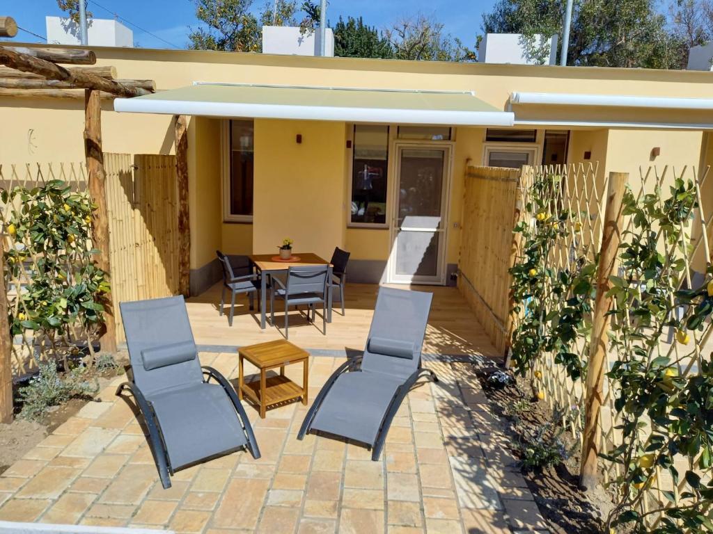 eine Terrasse mit Stühlen und einem Tisch vor einem Haus in der Unterkunft Bamboo in Procida