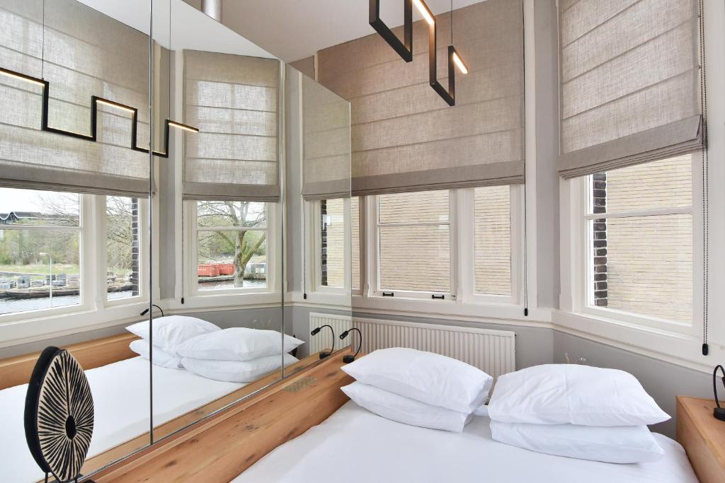 twee bedden in een kamer met ramen bij Boutique Hotel Havenkantoor in Den Haag