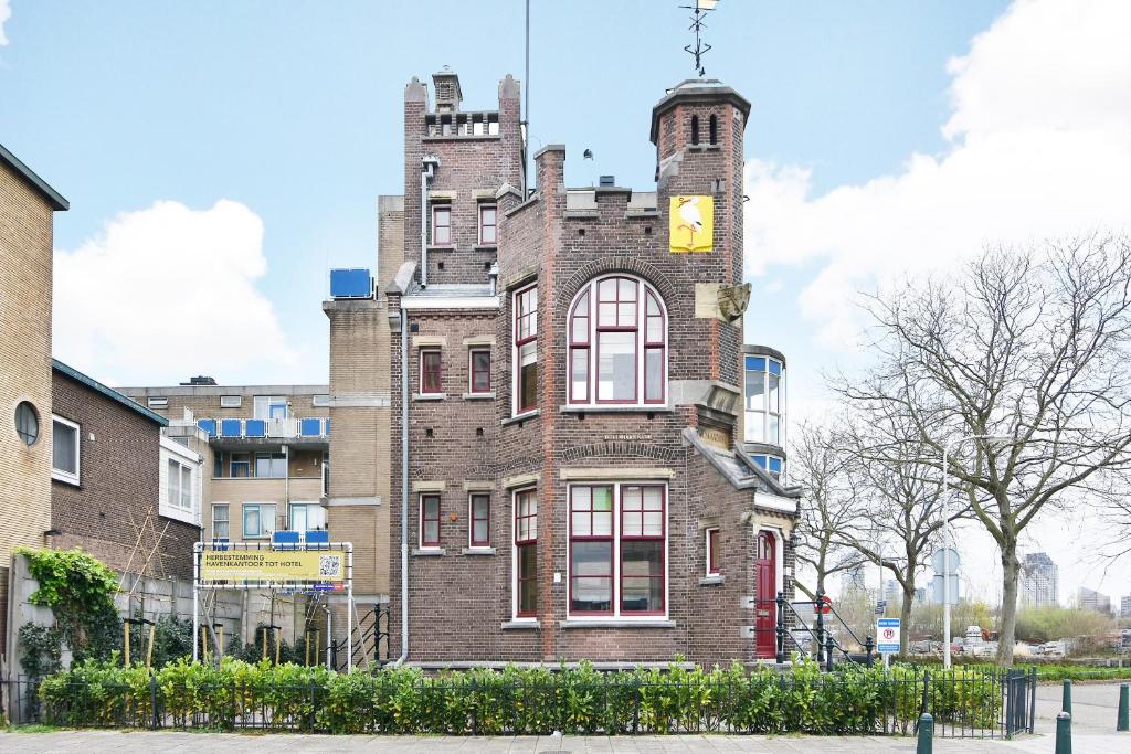 een hoog bakstenen gebouw met een klokkentoren bij Boutique Hotel Havenkantoor in Den Haag