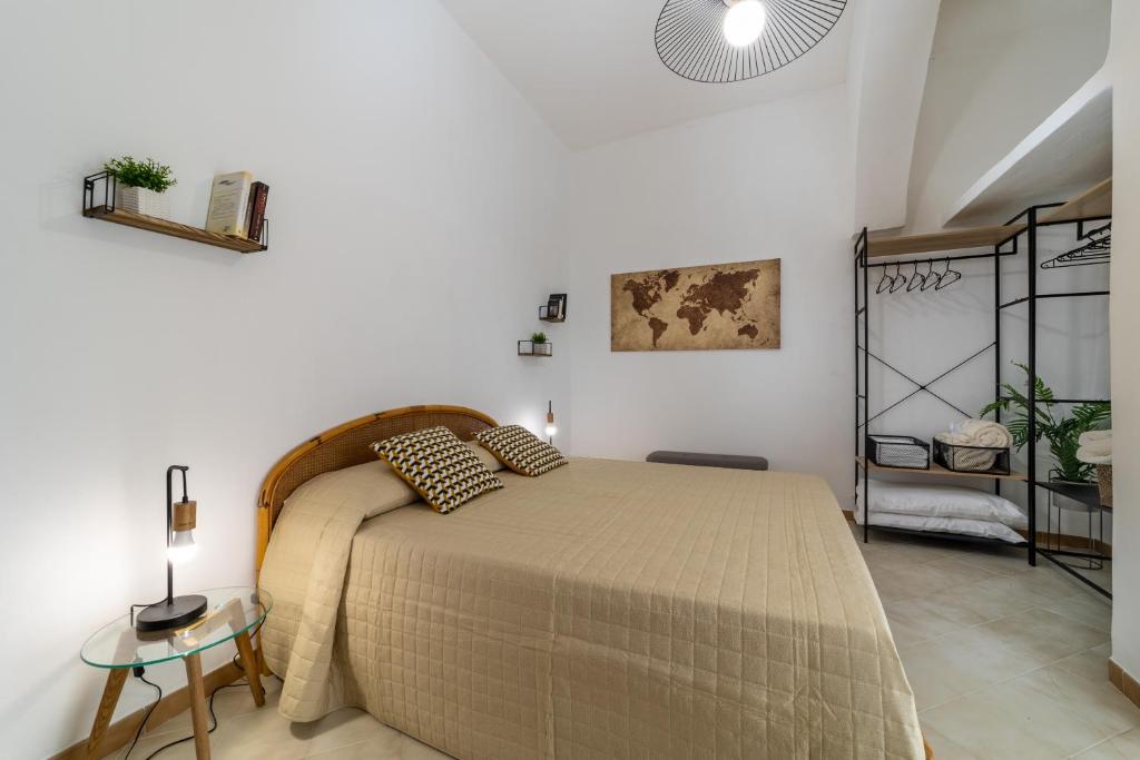 Dormitorio blanco con cama y mesa en La Casa Di Maya, en Marsala