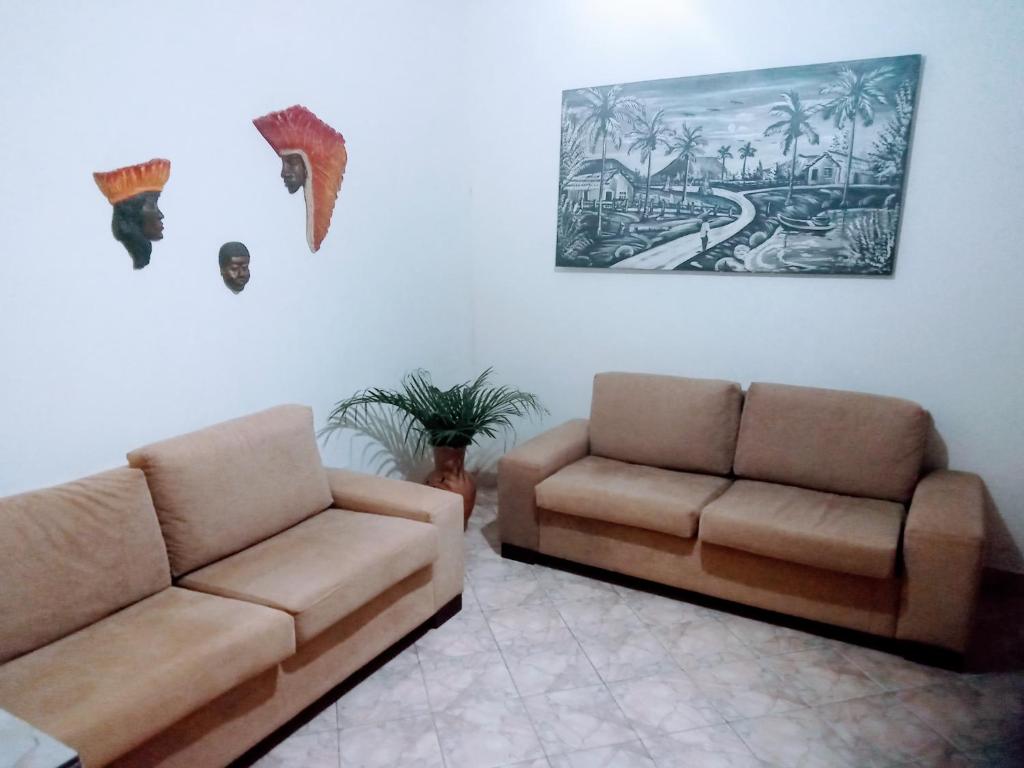 een woonkamer met twee banken en een schilderij aan de muur bij Pousada e Hostel Chapada Suites in Lençóis