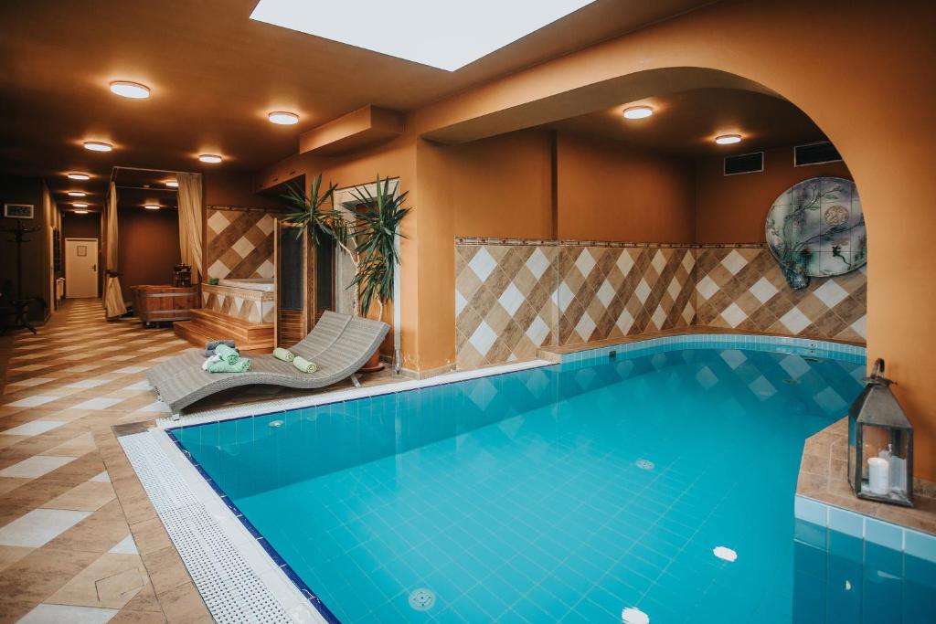 a swimming pool in a hotel room with a tile floor and a large pool at Hotel Ruze in Český Krumlov