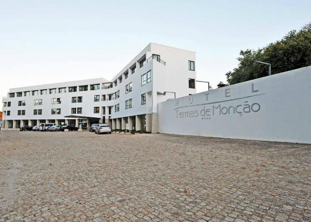 um grande edifício branco com um cartaz em Hotel Bienestar Termas de Moncao em Monção