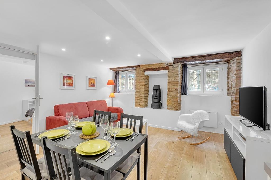 a dining room and living room with a table and chairs at LE CONSTANTIN - Charmant souplex de 34m2 in Toulouse