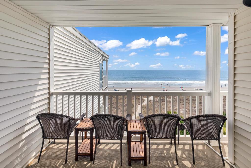 マートルビーチにあるBright and Sunny Condo with Stunning Oceanfrontのビーチの景色を望むポーチ(椅子、テーブル付)