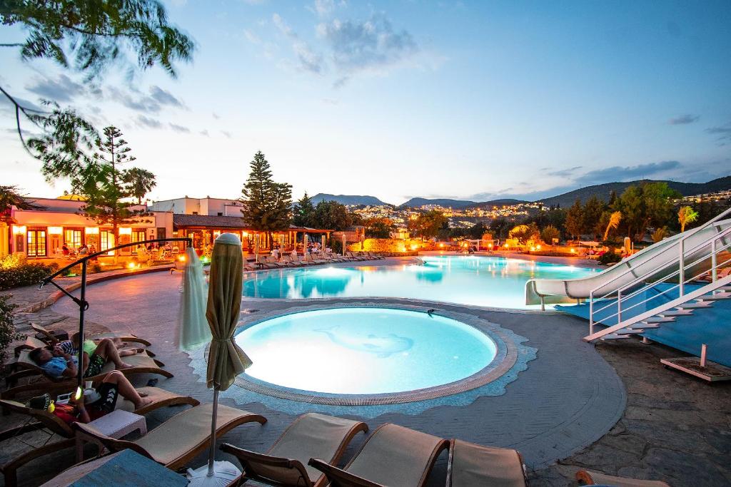 ein großer Pool mit Liegestühlen und ein Resort in der Unterkunft Museum Resort Spa in Bodrum City