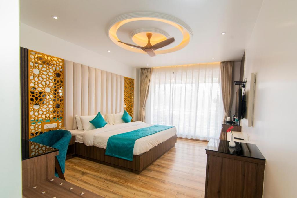 1 dormitorio con cama y lámpara de araña en Hotel Yog Vashishth, en Rishīkesh