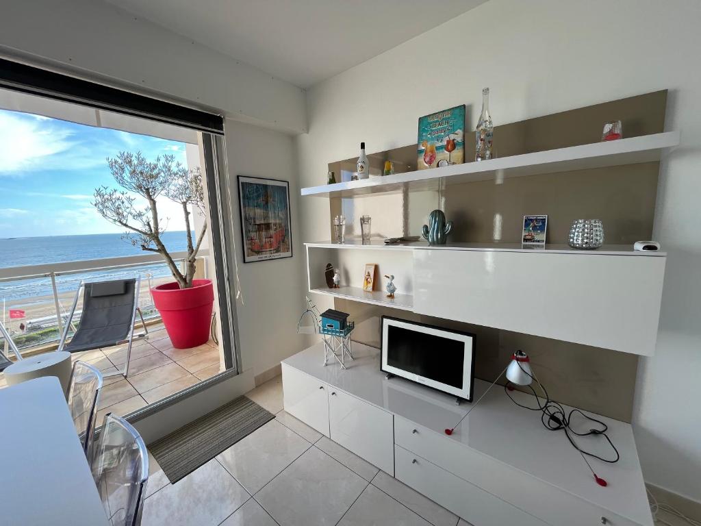 a living room with a television and a large window at Malibu Beach LA BAULE appartement face à la mer ! in La Baule