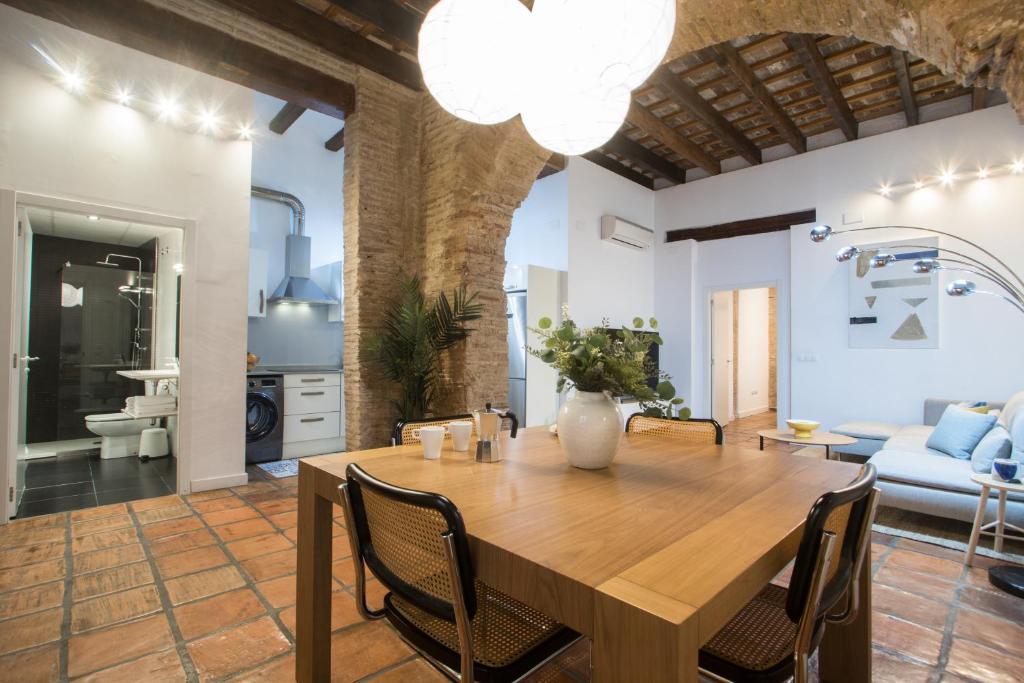 une cuisine et une salle à manger avec une table et des chaises en bois dans l'établissement Apartamentos La Xerea, à Valence
