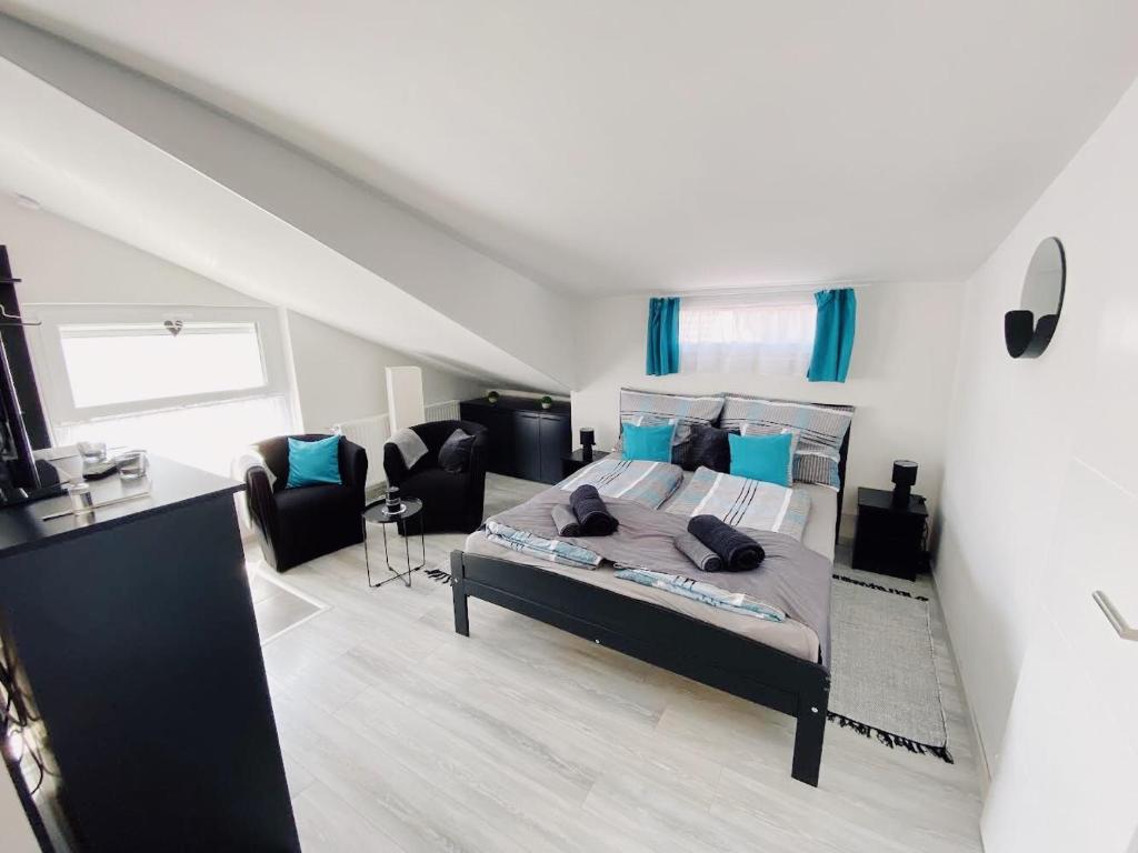 ein Schlafzimmer mit einem Bett mit blauen Kissen in der Unterkunft Tramini Apartmanok in Eger