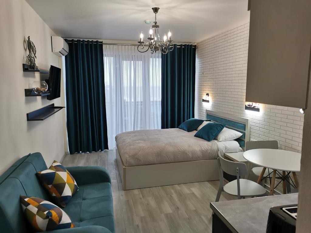 ein Schlafzimmer mit einem Bett und ein Wohnzimmer in der Unterkunft Orbi beach tower in Batumi