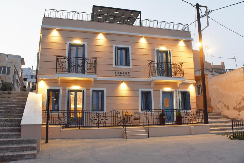 a large white house with stairs in front of it at Syrene Luxury Suites in Ermoupoli