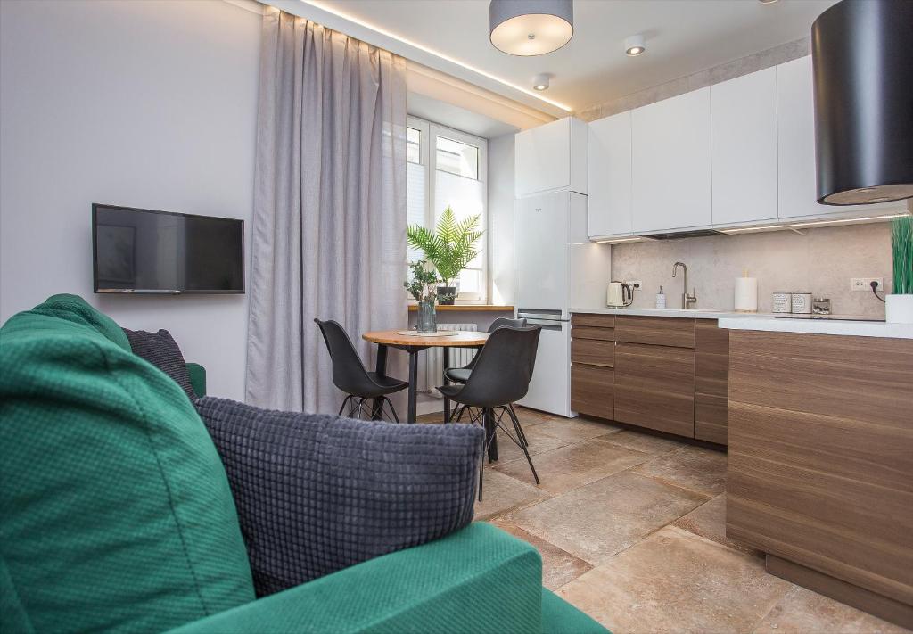 a kitchen and living room with a couch and a table at Urban Jungle apartment in the heart of the city in Białystok