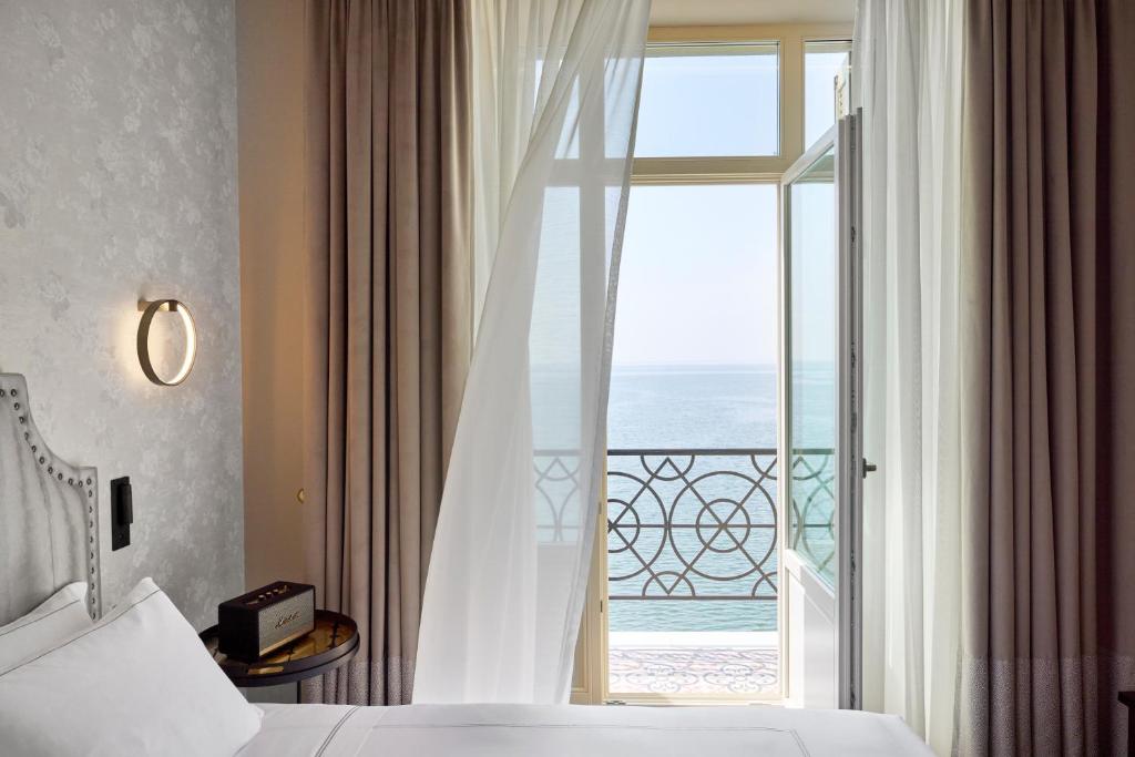 a bedroom with a window with a view of the ocean at ON Residence - Small Luxury Hotels of the World in Thessaloniki