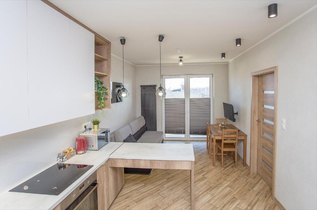 a kitchen with a table and a dining room at Urban Jungle - Vera Apartment in Białystok