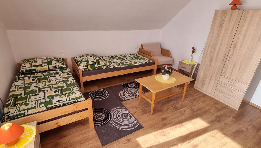a small room with two beds and a table at Boglári Harmónia Apartman in Balatonboglár