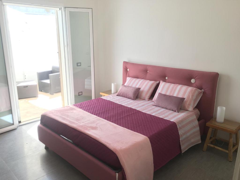 Un dormitorio con una cama grande con sábanas y almohadas púrpuras. en Dear Mary B&B, en San Cesario di Lecce