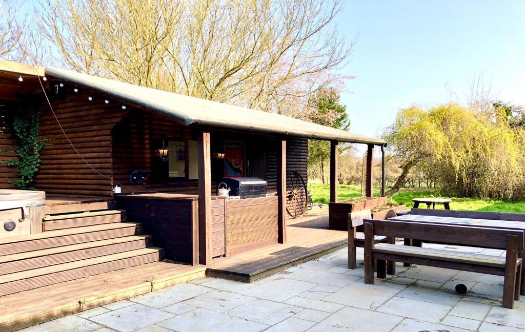 a wooden cabin with a picnic table and a bench at Woolston lodge in Oswestry
