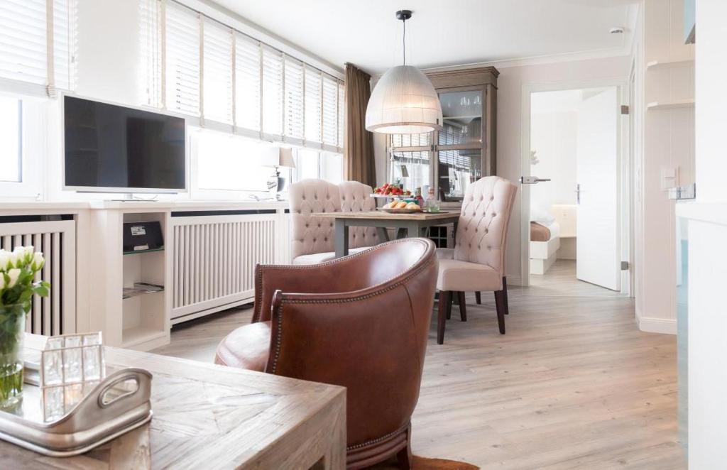 ein Wohnzimmer mit einem Tisch und ein Esszimmer in der Unterkunft Ad3 5F Luxury West in Westerland