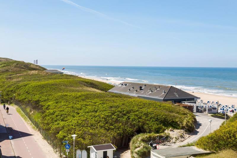 uma vista para uma praia com um edifício e o oceano em F 41_ App_ 401 em Westerland