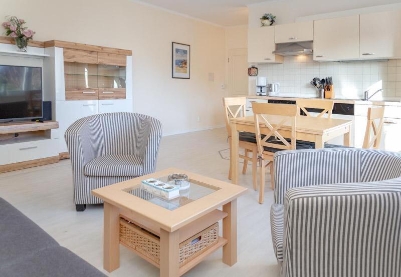 uma sala de estar com cadeiras e uma mesa e uma cozinha em Haus Lia Links App 3 em Tinnum