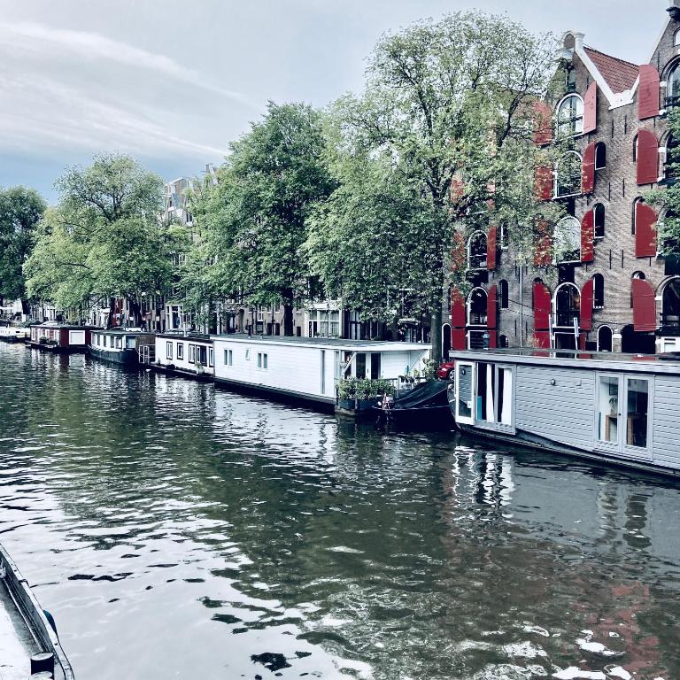 un groupe de bateaux sur une rivière devant les bâtiments dans l'établissement Houseboat Bonnie, à Amsterdam