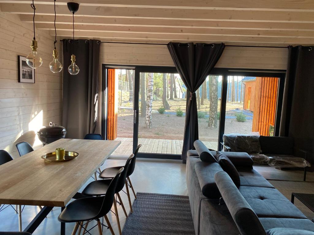 un soggiorno con tavolo e divano di Mazurskie Klimaty - domy z widokiem a Tomaszkowo