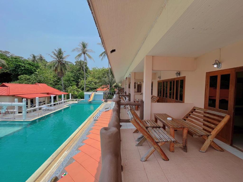 a balcony with benches and a swimming pool at Paradise Bungalows in Haad Rin