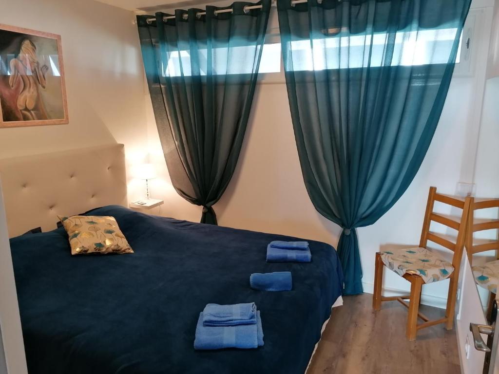 ein Schlafzimmer mit einem blauen Bett und einem Stuhl in der Unterkunft Cap Agde Natu Port Ambonne in Cap d'Agde