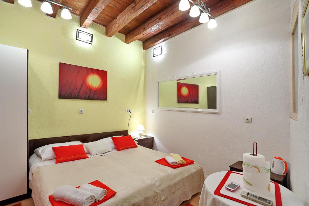 - une chambre avec 2 lits et des serviettes rouges et blanches dans l'établissement Apartment City Center Dragica, à Zadar