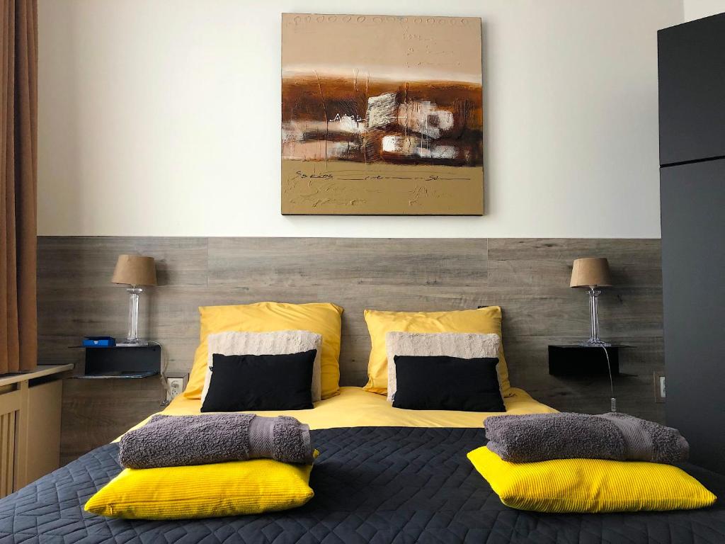 1 dormitorio con 1 cama amarilla y 2 almohadas en Bolton Boulevard Beach Rooms, en Vlissingen