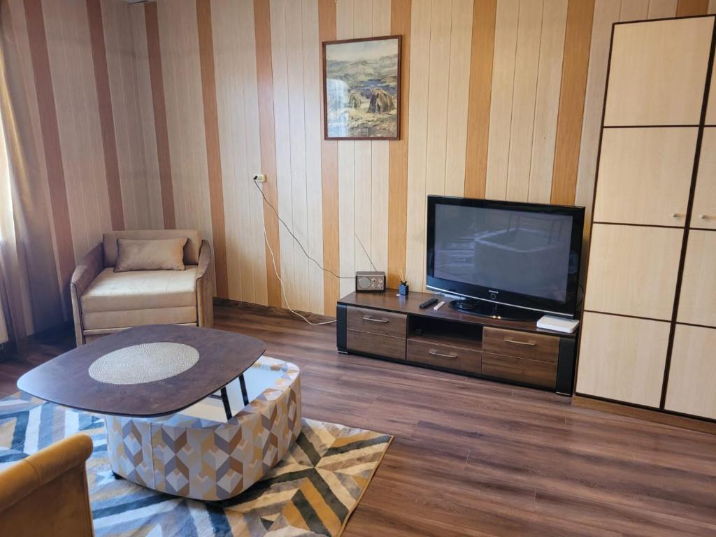 Talsi 2 rooms and backyard في تالسي: غرفة معيشة مع تلفزيون وطاولة قهوة