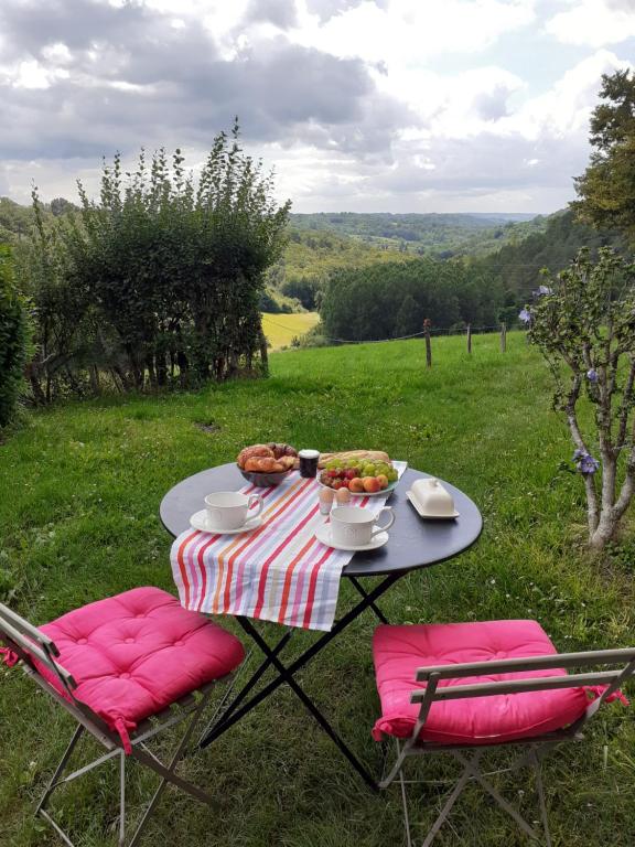 a table with a plate of food and two chairs at Chambre d'hôtes La grange in Chalagnac