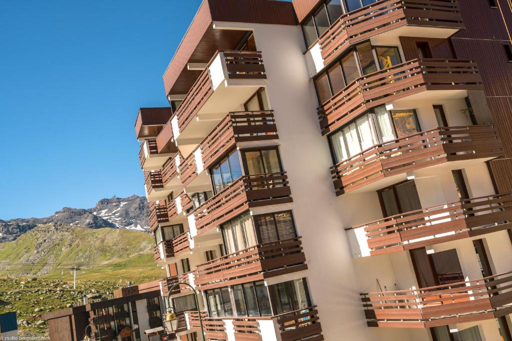 a tall building with wooden balconies on it at Résidence Pierre & Vacances Le Schuss in Val Thorens