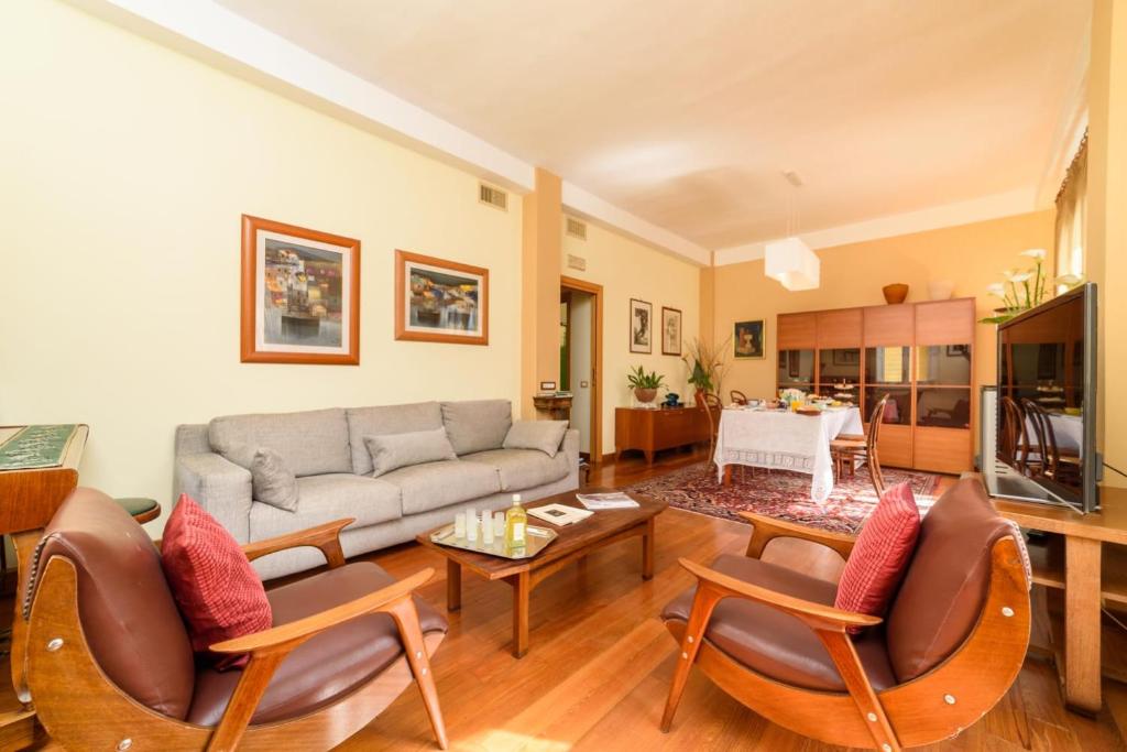 een woonkamer met een bank, stoelen en een tafel bij La Camelia Apartment in Sorrento