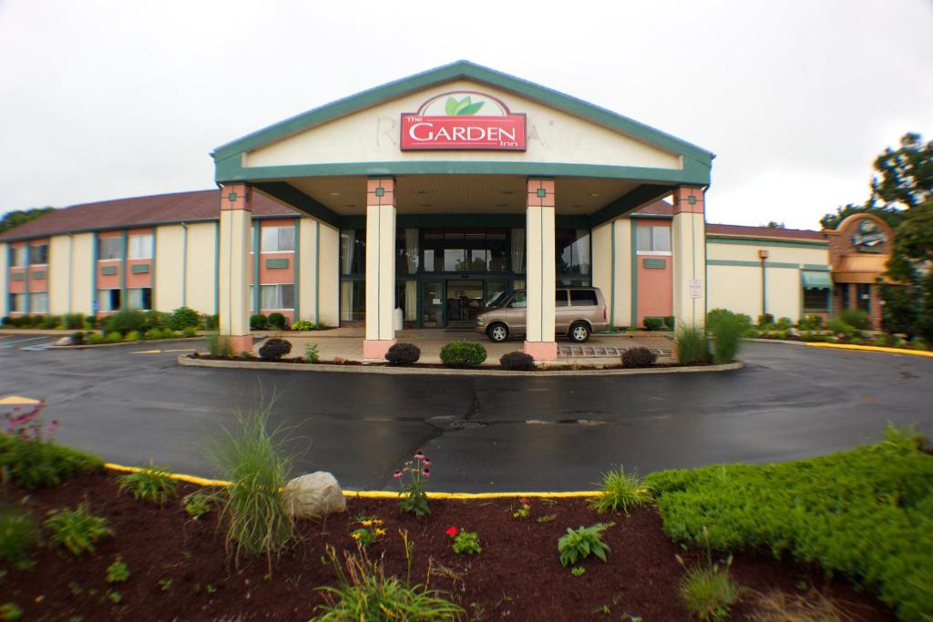 a car dealership with a cariman sign in a parking lot at The Garden Inn in Elkhart