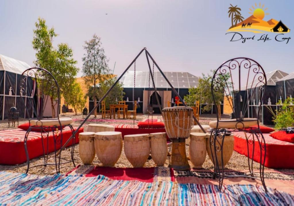 a park with a playground with tables and swings at Desert Life Camp in Merzouga