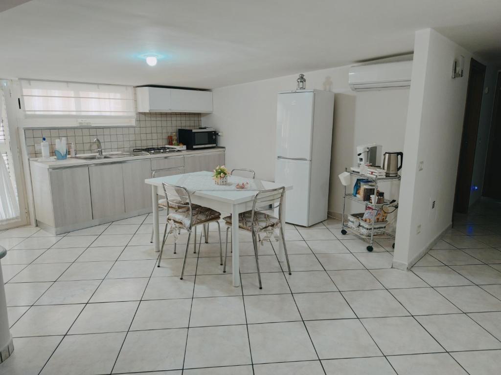 una cucina con tavolo, sedie e frigorifero di House da Mary a Caserta