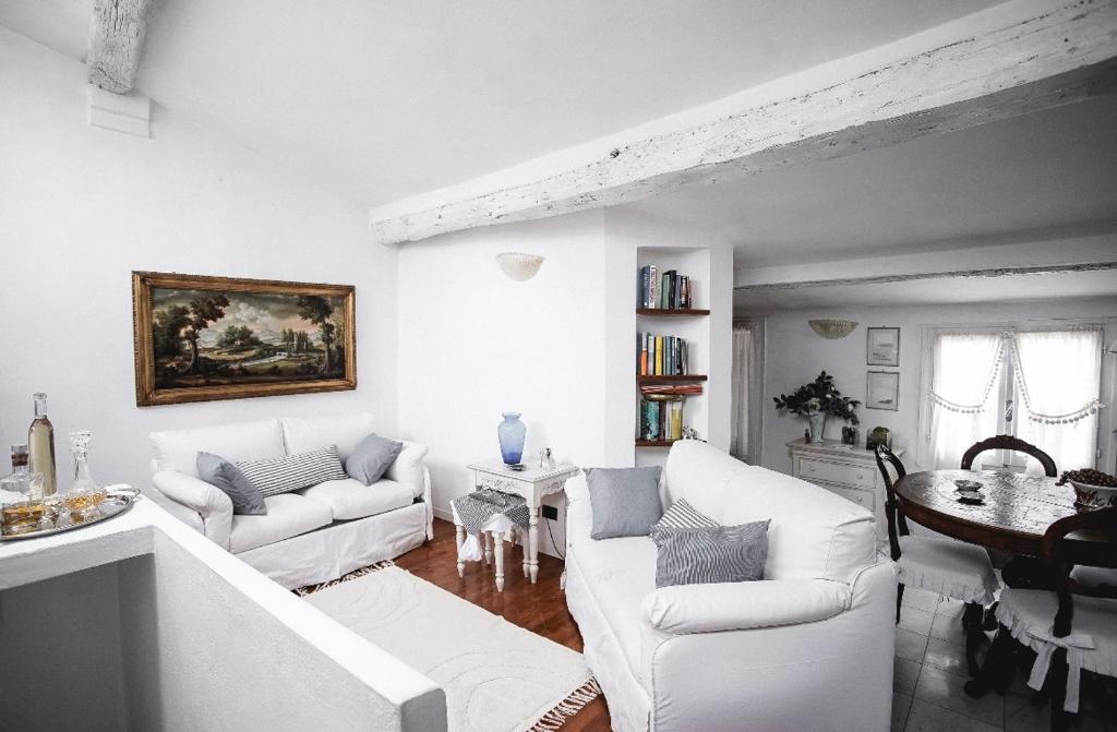 ein weißes Wohnzimmer mit weißen Sofas und einem Tisch in der Unterkunft Casa vacanze Cinzia in Lerici