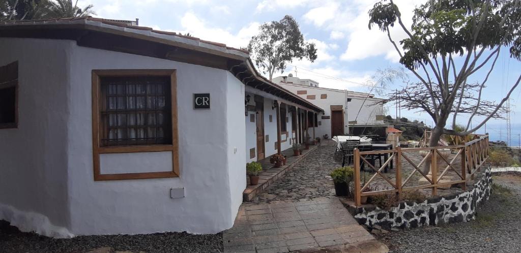 ein weißes Gebäude mit einer Tür und einem Zaun in der Unterkunft Casa Rural Finca Las Dulces in Chío