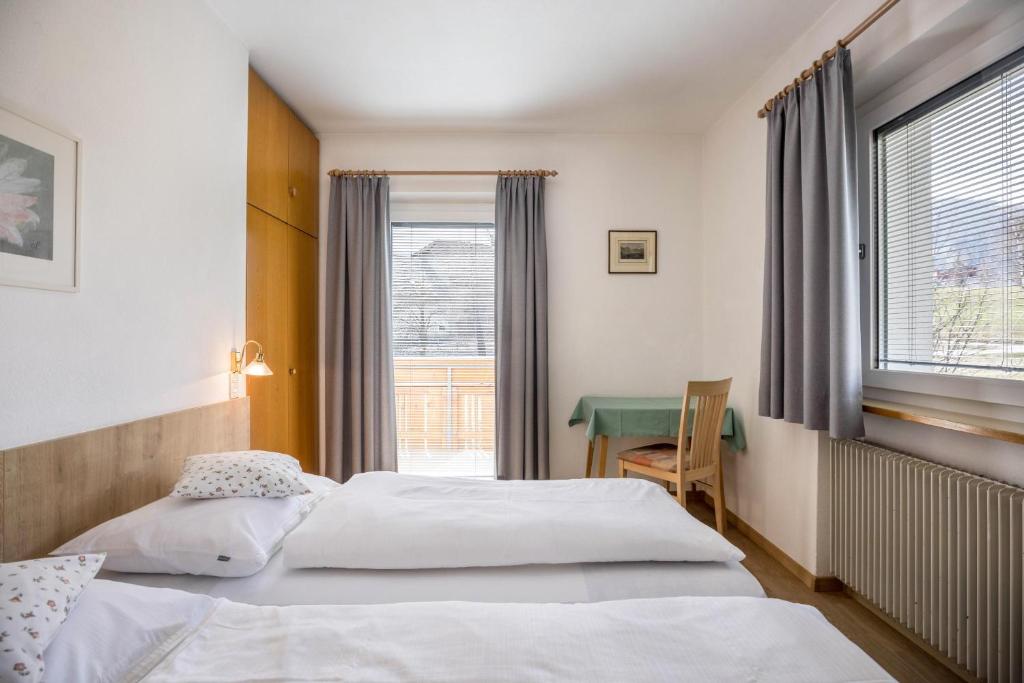 een hotelkamer met 2 bedden en een tafel bij Unterhauserhof App A in Valdaora