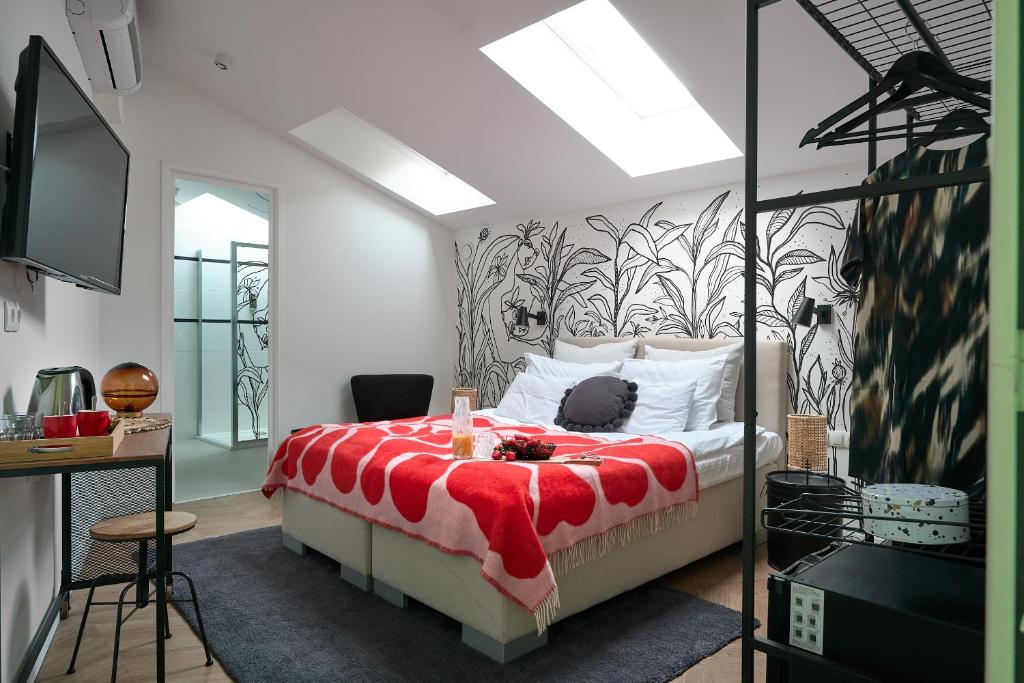 um quarto com uma cama com um cobertor vermelho em Butik Art Hotel em Budapeste