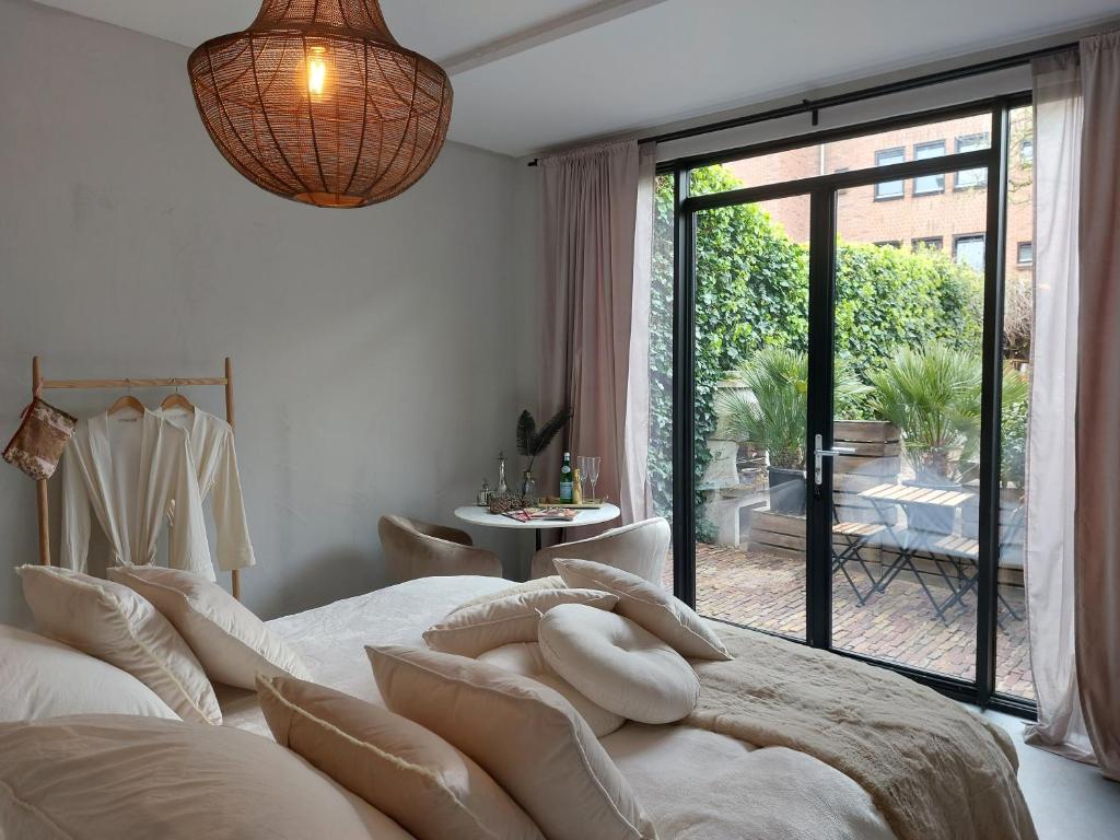 a bedroom with a large bed with a large window at Saya Boutique Hotel in Amersfoort