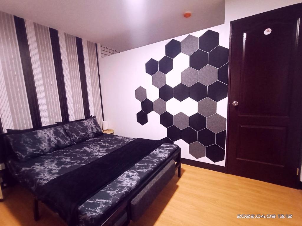 1 dormitorio con 1 cama con pared hexagonal en Relaxing 1-Bedroom Condo Unit (by Lee Portum), en Marilao