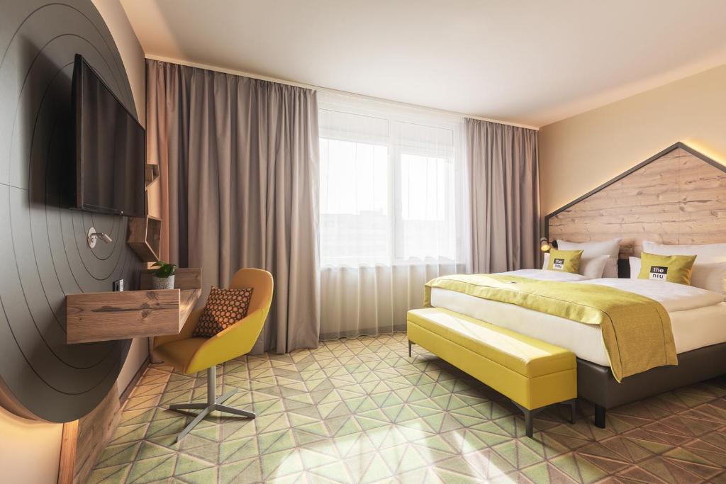 una camera d'albergo con letto, scrivania e TV di the niu Mill a Colonia